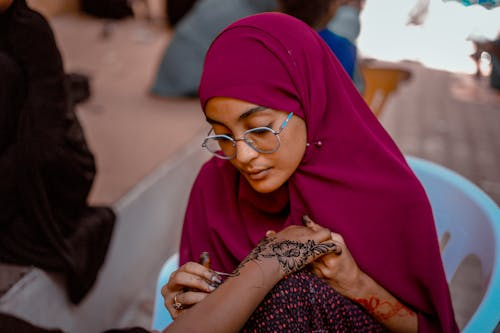 Somali woman applying henna art